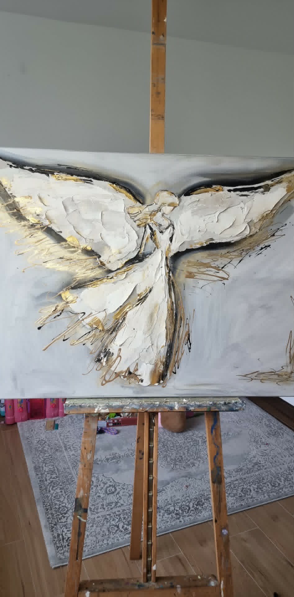 Oil painting of a white bird with spread wings on canvas mounted on a wooden easel